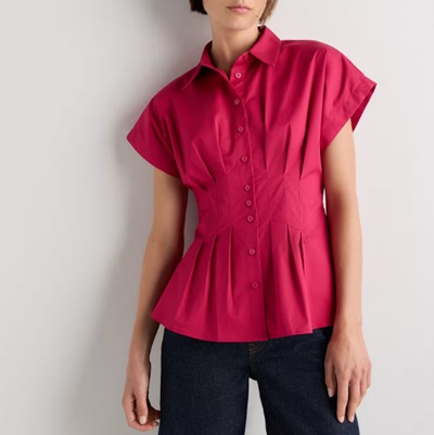 A woman wearing black pants and a dark pink pleated top