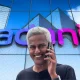 Composite image showing headshot of Ravi Nair in front of facade of Adani office building