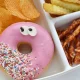 Illustrative image of unhealthy school lunch including a doughnut, chips, crisps and twiglets. School lunch menus.