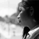 A black and white portrait of a woman gazing out of a window, capturing reflection and contemplation, in relation to the autism strategy story