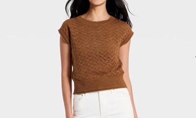 A woman wearing a short-sleeve brown sweater and white pants
