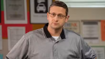 Tim Robinson in glasses and a gym shirt with his hands on his hips in I Think You Should Leave