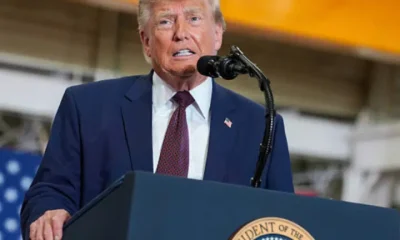 Donald Trump at a mic stand mid-speech