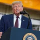 Donald Trump at a mic stand mid-speech