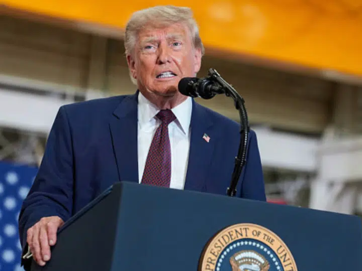 Donald Trump at a mic stand mid-speech