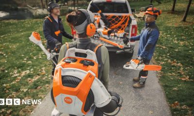 Leaves fly everywhere as a man uses an leaf blower