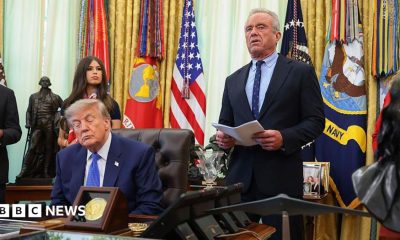 Donald Trump speaks from a lectern during a news conference at the White House. He is accompanied by Robert F Kennedy Jr.