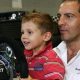 A young Kimi Antonelli sitting in a go-kart while wearing racing overalls and a racing helmet