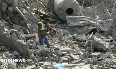 An emergency worker looks through rubble in the aftermath of an airstrike on Ansar in Lebanon
