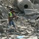 An emergency worker looks through rubble in the aftermath of an airstrike on Ansar in Lebanon