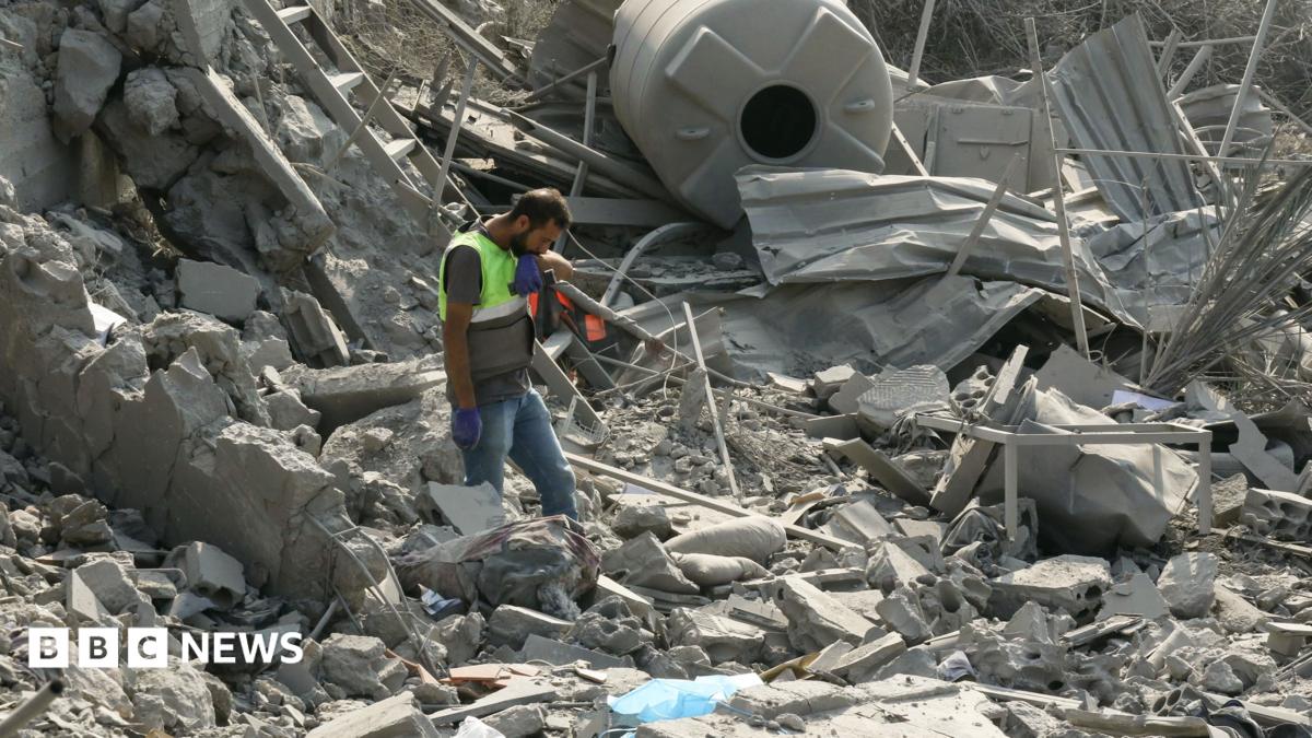 An emergency worker looks through rubble in the aftermath of an airstrike on Ansar in Lebanon