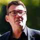 Andy Burnham wearing a dark suit and glasses.