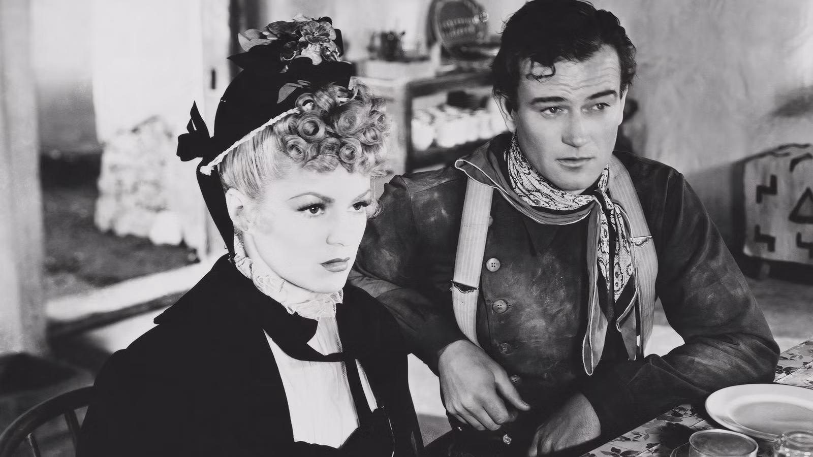 Claire Trevor and John Wayne in Stagecoach sitting next to each other