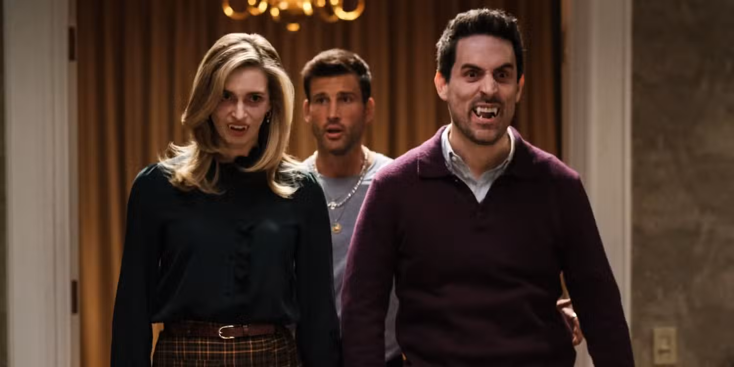 Three people standing, one bearing vampire teeth in Eternally Yours.