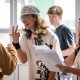 A group of students gather around holding papers and gesturing to each other while reading their results at a high school in Cardiff on Thursday.