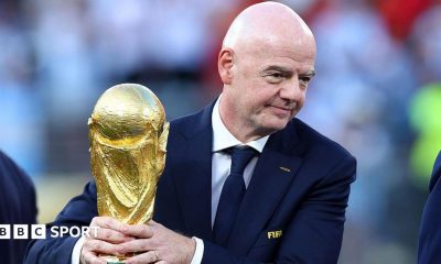 Gianni Infantino with his hands around the men's World Cup trophy