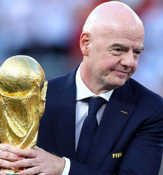 Gianni Infantino with his hands around the men's World Cup trophy