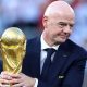 Gianni Infantino with his hands around the men's World Cup trophy