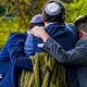 Worshippers console each other after the attack o0n their synagogue while a police officer looks on.