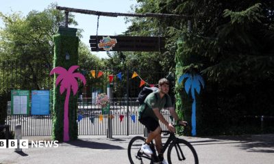 The closed gates of the theme park with a staff member in front