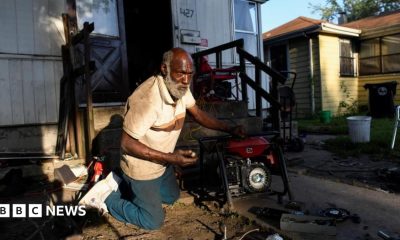 Anthony Lewis repairs a generator at his home while coping without electricity, as thousands of residents remain without power more than a week after severe storms struck Gary, Indiana.