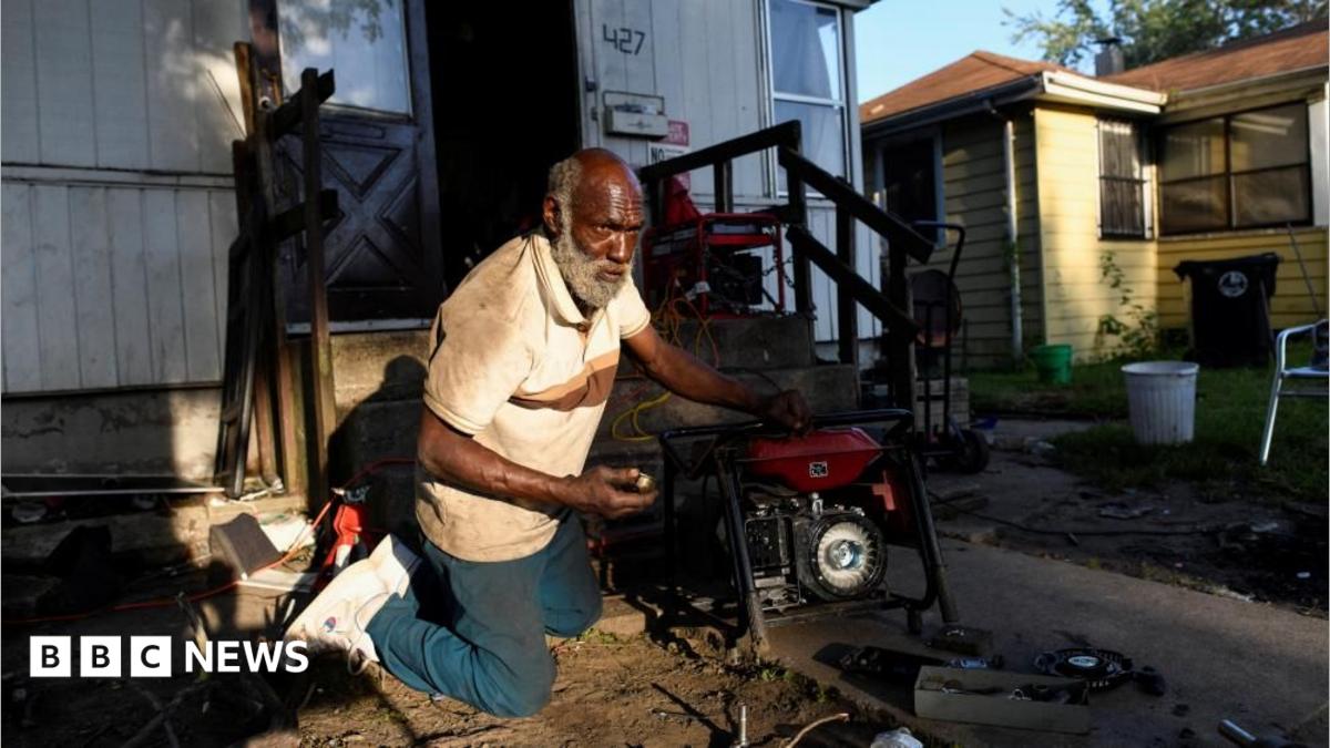Anthony Lewis repairs a generator at his home while coping without electricity, as thousands of residents remain without power more than a week after severe storms struck Gary, Indiana.