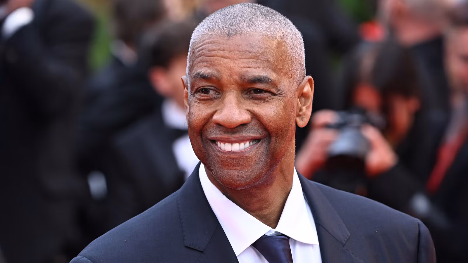 Denzel Washington smiles on the red carpet