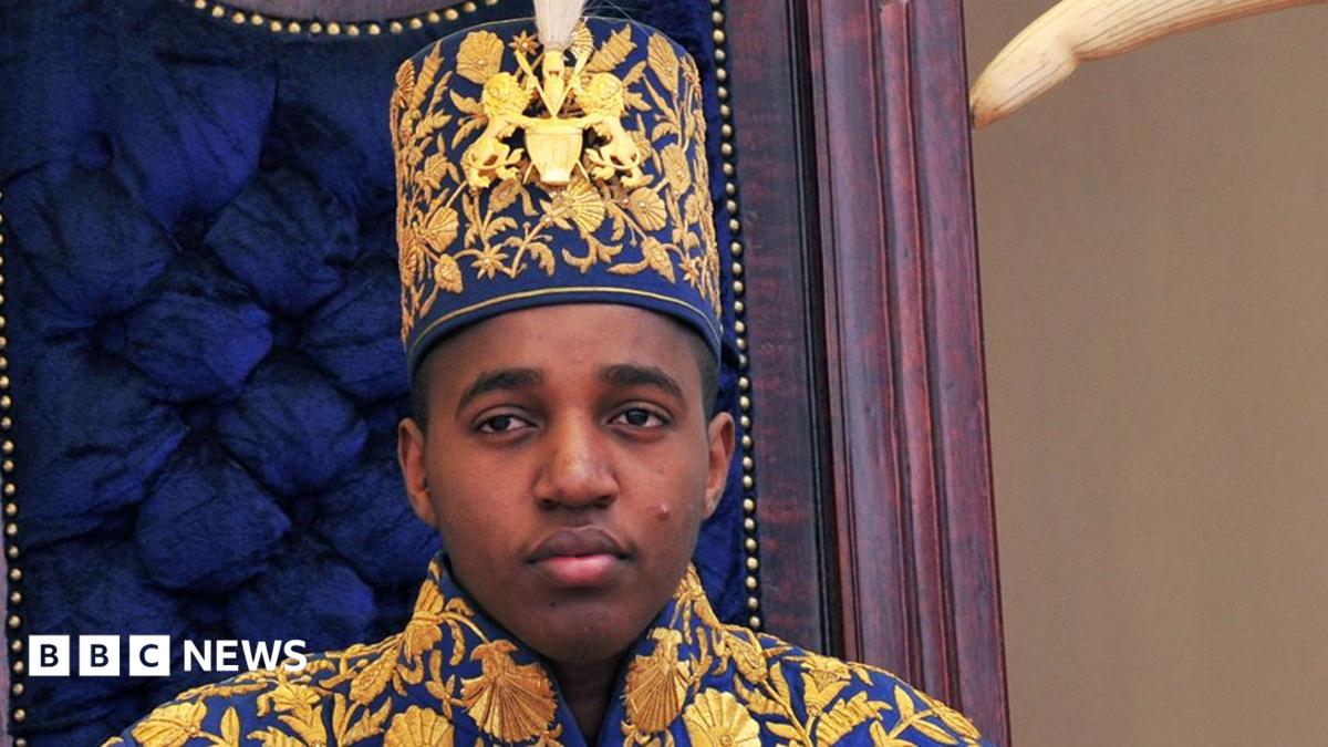 King Oyo pictured at 18 during his coronation wearing a gold embroidered jacket and hat.