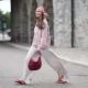 COPENHAGEN, DENMARK - JULY 06: Evi Wave wears a red and white check headscarf, long straight brown hair with a center part, a pink and white knit crew-neck sweater with long sleeves, cream white satin wide-leg pants, a burgundy woven shoulder bag, burgundy sandals shoes, outside Marimekko, during Copenhagen Fashion Week Spring/Summer 2027, on July 06, 2026 in Copenhagen, Denmark (Photo by Edward Berthelot/Getty Images)