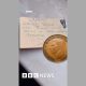 An old penny on top of a piece of card - on it is written: David Judd - one pint of best beer if penny returned