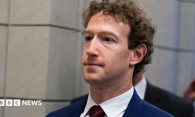 Mark Zuckerberg, CEO of Meta, wearing a dark blue suit with a dark red tie