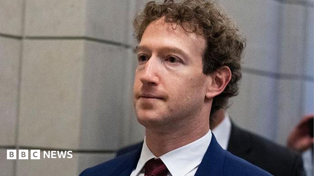 Mark Zuckerberg, CEO of Meta, wearing a dark blue suit with a dark red tie
