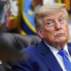 Donald Trump glances to his right while seated at his desk in the Oval Office.