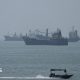 Large ships in the Strait of Hormuz are visible near the beach of Bandar Abbas.