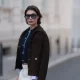 BERLIN, GERMANY - JUNE 08: Sarah Posch seen wearing a Sandro look, a cropped navy top layered under a dark brown jacket, paired with white wide leg trousers, black Soera ballerinas, a creme Coach bag, and sunglasses by A. Kjaerbede on June 08, 2026 in Berlin, Germany. (Photo by Jeremy Moeller/Getty Images)