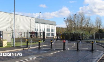 The Elbit Systems UK factory in Filton, near Bristol. There are metal gates blocking access to the building, which is white and grey.