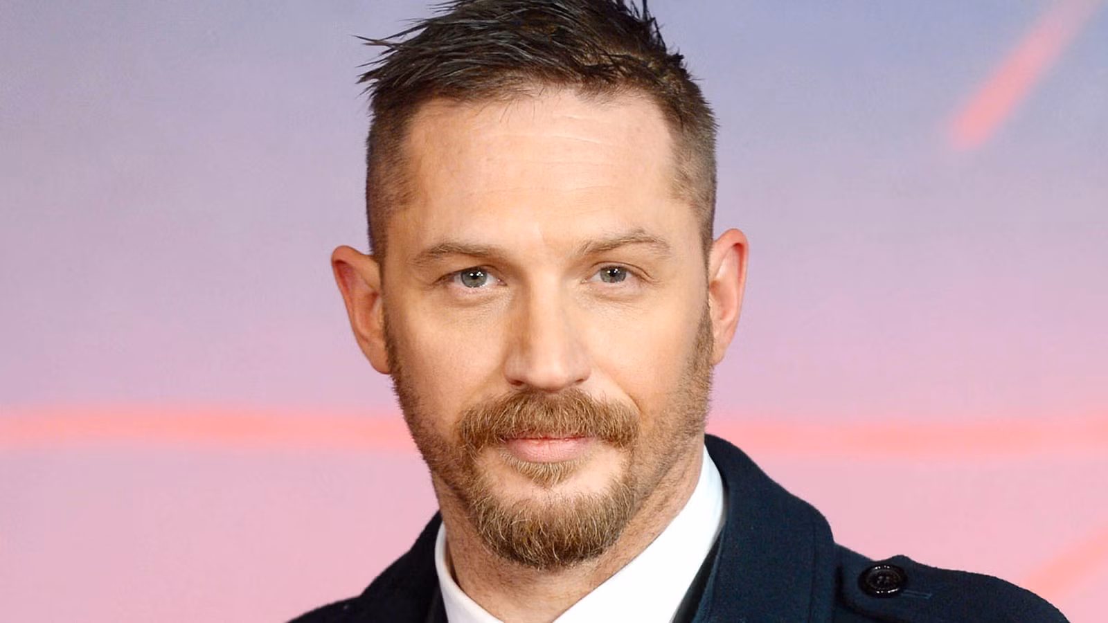 Tom Hardy looking directly at the camera with a slight smile