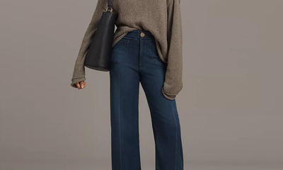 woman wears slouchy sweater with wide leg jeans and sandals; the jeans are actually a knit
