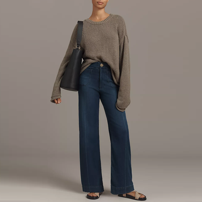 woman wears slouchy sweater with wide leg jeans and sandals; the jeans are actually a knit
