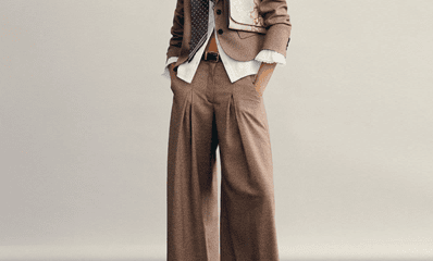 woman wears wide-leg pantsuit; her blouse is untucked and she's wearing a floppy bowtie (no comment on the bowtie)
