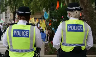 Two uniformed police officers walking with their back to the camera. Hackers have infilrated the national police system.