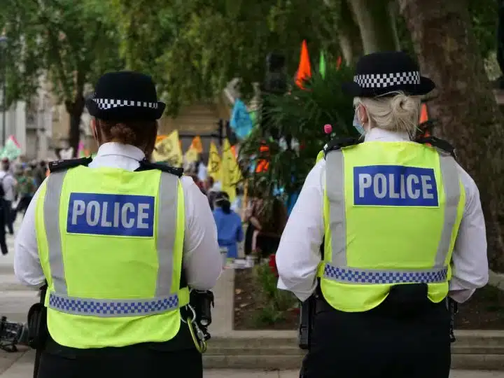 Two uniformed police officers walking with their back to the camera. Hackers have infilrated the national police system.