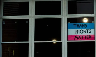 EHRC: A 'Trans Rights Matter' sign displayed in one pane of a large glass window which is dark
