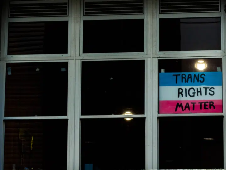 EHRC: A 'Trans Rights Matter' sign displayed in one pane of a large glass window which is dark