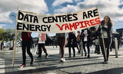Protestors against AI data centres holding a banner that reads, "Data centres are energy vampires"