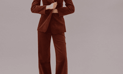 woman pulls a brown corduroy blazer tighter in front