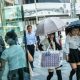 Women walk with umbrellas to shield themselves from the sun in Tokyo