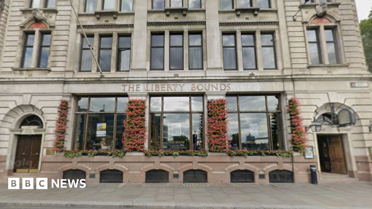 The exterior of a pub with large windows and flowers growing on the walls