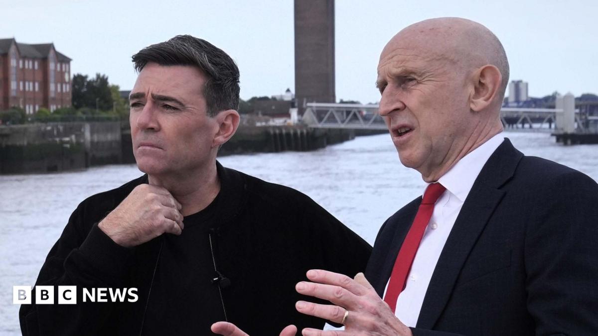 John Healey makes a point with his hands to a thoughtful looking Andy Burnham, who is gazing out across the Mersey river on a ferry in Liverpool