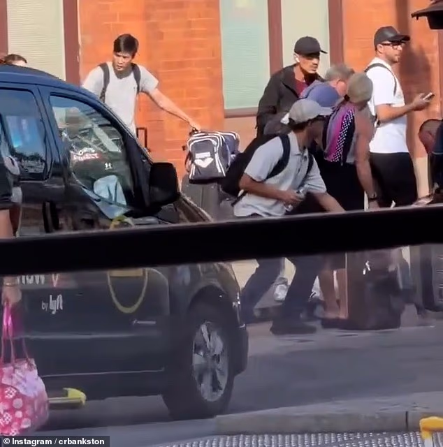 Footage shows a man bending down to pick up the suitcase while its owner has her back turned
